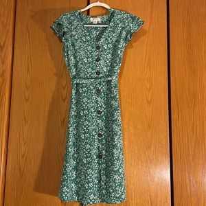 Green midi length dress with floral pattern.